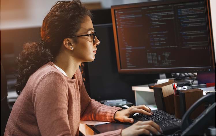 Woman sitting in front of computer coding - 3 Cybersecurity Storytelling Strategies for COVID 