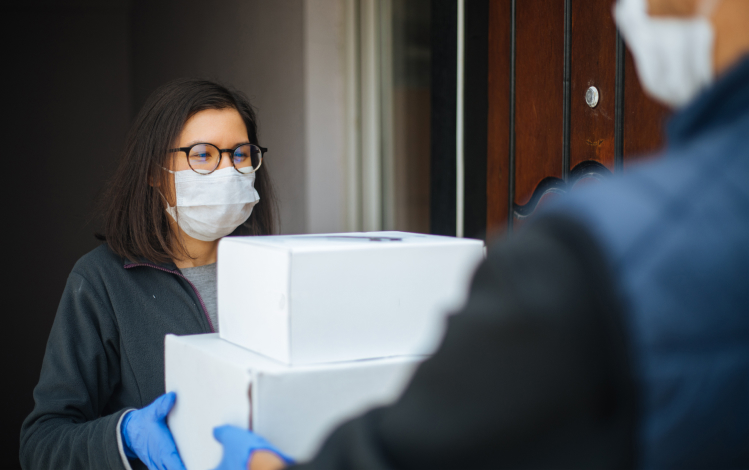 Leveling the Playing Field for Brands and Customers in 2021 - Woman in medical mask receiving boxes