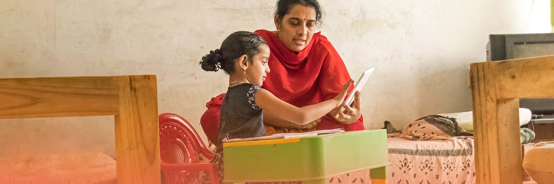 Woman and young girl at table - India's development sector adapting to the new ecosystem whitepaper