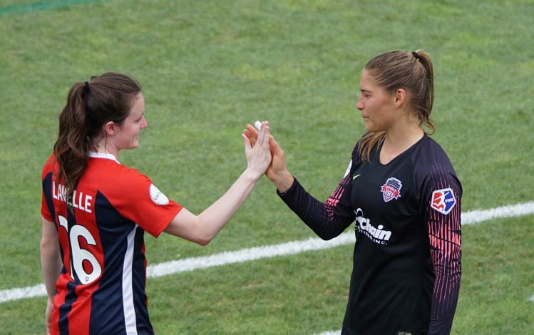 Two Women Soccer Players Holding Hands - Survival of the Bravest Hero Image