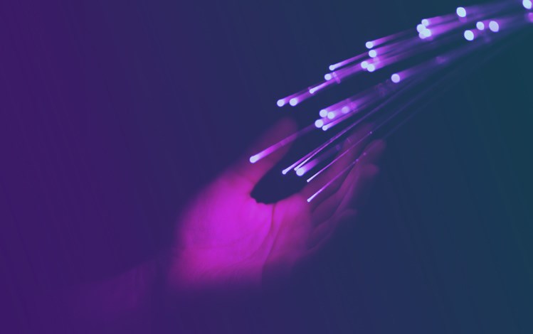 Colorful close up of hand touching optical fibers